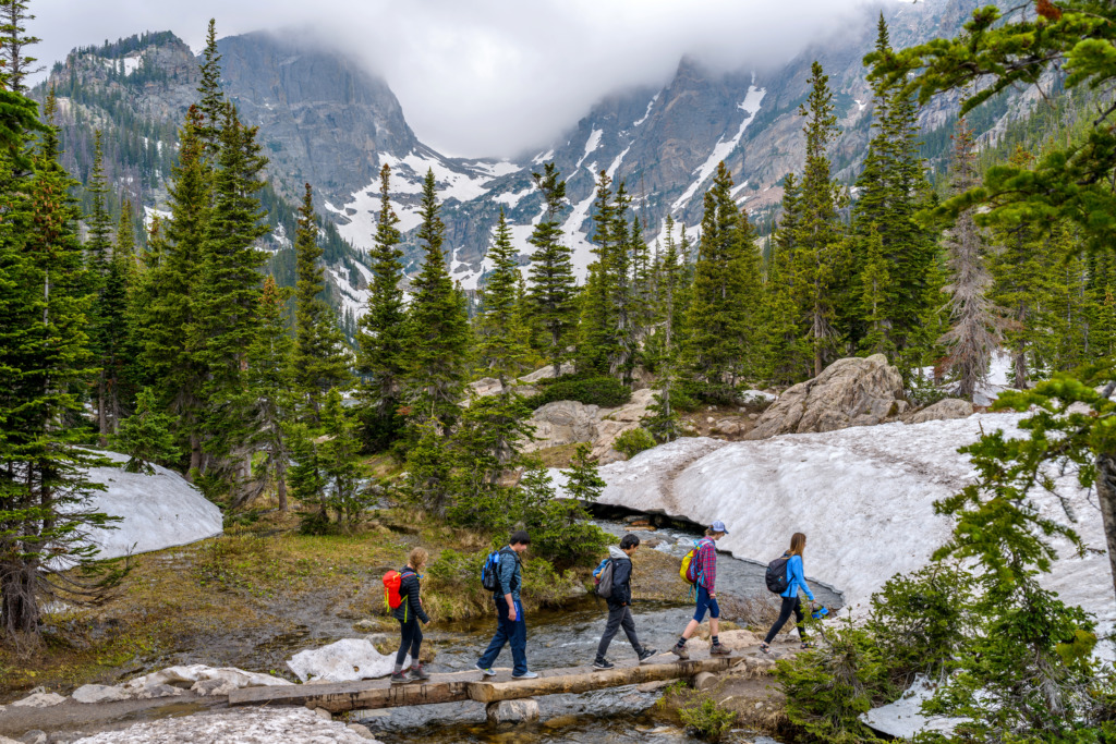 hikers crossing a river at estes park, Colorado